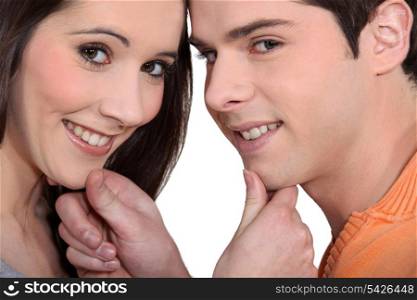 couple embracing and holding their chins