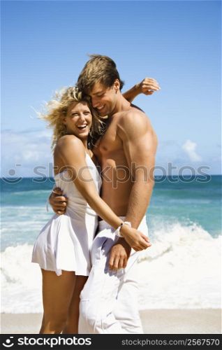 Couple embracing and smiling on Maui, Hawaii beach.