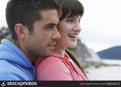 Couple embracing at ocean, smiling, close-up