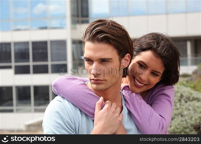 Couple embracing in front of building