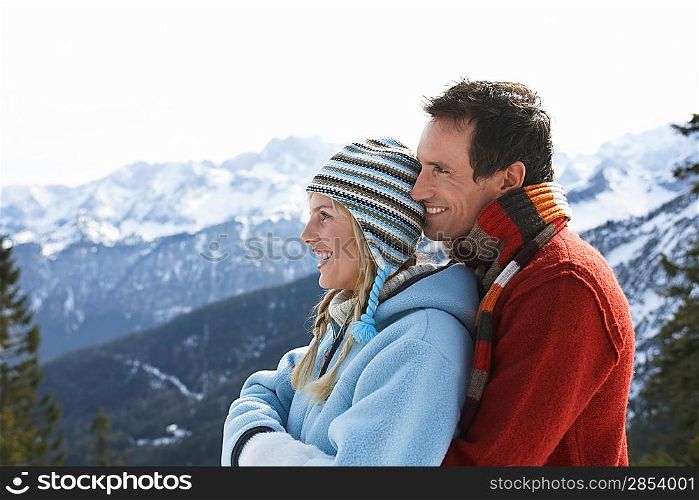 Couple embracing on mountain peak side view