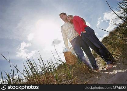 Couple embracing on sand dune