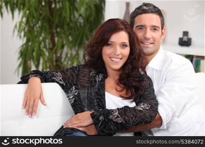 Couple embracing on white sofa