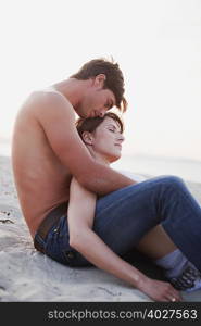 couple embracing sitting on the beach