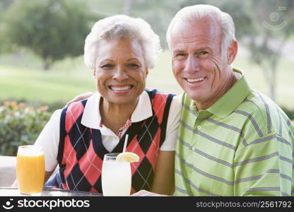 Couple Enjoying A Beverage By A Golf Course