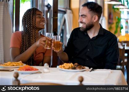 Couple enjoying and spending good time while having lunch together at a restaurant. Relationship concept.