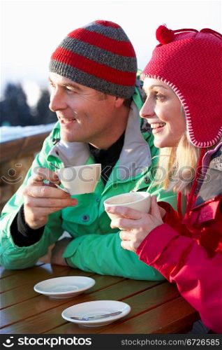 Couple Enjoying Hot Drink In Cafe At Ski Resort