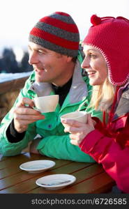 Couple Enjoying Hot Drink In Cafe At Ski Resort