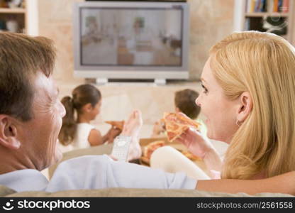 Couple Enjoying Pizza In Front Of TV