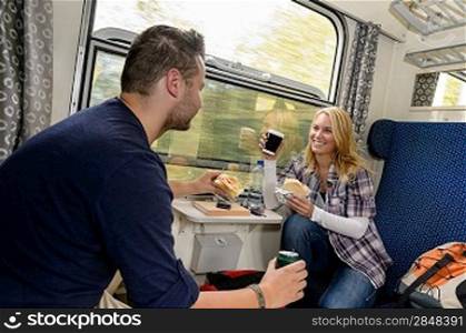 Couple enjoying sandwiches traveling with train smiling woman man vacation