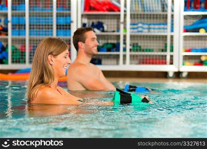 Couple exercising Aquarobics or hydrotherapy in spa