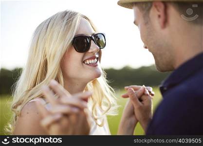 Couple face to face and holding hands in park