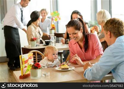 Couple feeding their child cake at cafe restaurant woman man