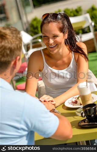 Couple flirting holding hands at cafe bar restaurant terrace sunny