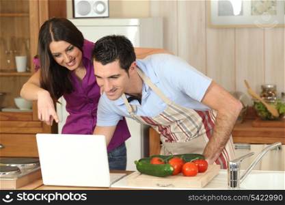 Couple following a recipe on a laptop