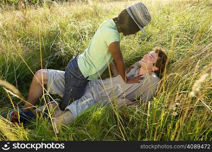 Couple fooling around in a field