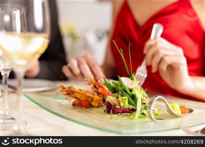 Couple for romantic Dinner or lunch in a gourmet restaurant drinking wine and eating