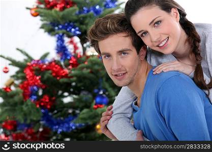 Couple gathered by Christmas tree