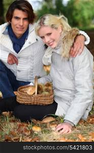 Couple gathering mushrooms in basket