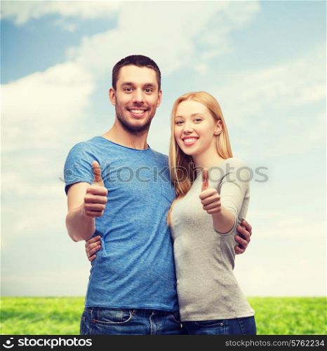 couple, gesture and family concept - smiling couple showing thumbs up