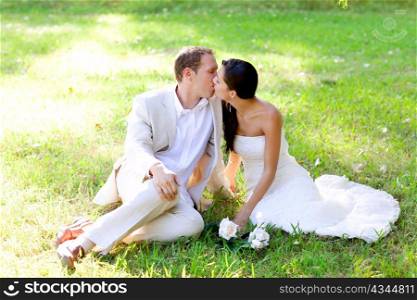 couple happy in love kissing sitting in park green grass