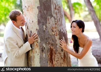 Couple happy in love playing in a tree trunk outdoor park