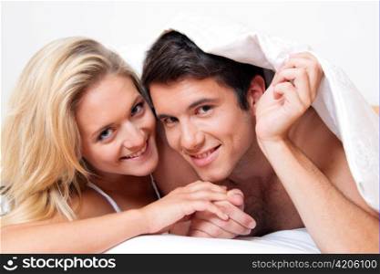 couple has fun in bed. laughter, joy and eroticism in the bedroom