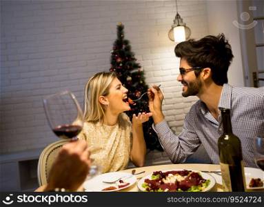 Couple have Christmas dinner in the beautifully decorated New Year interior with Christmas tree