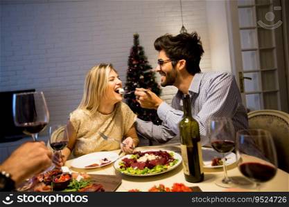 Couple have Christmas dinner in the beautifully decorated New Year interior with Christmas tree