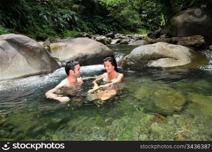 Couple having a bath in fresh river water