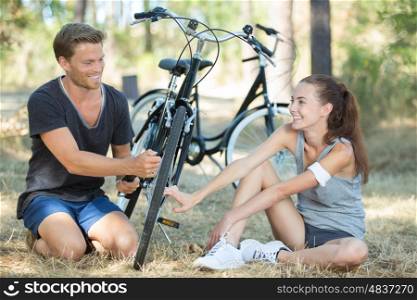 couple having a break while cycling through woodland