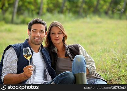 Couple having a glass of wine by a vineyard