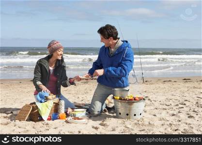 Couple Having Barbeque On Winter Beach