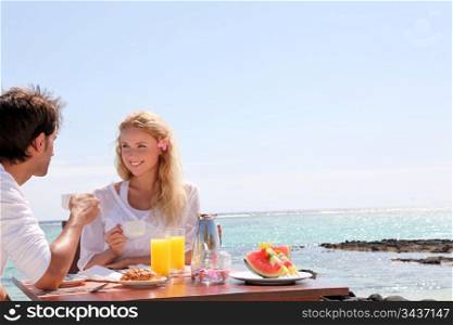 Couple having breakfast by blue lagoon