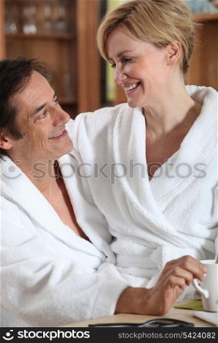 Couple having breakfast dressed in bathrobe
