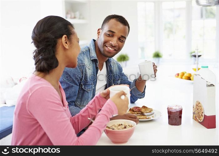 Couple Having Breakfast In Kitchen Together