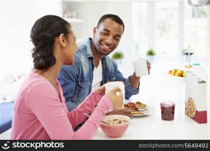 Couple Having Breakfast In Kitchen Together