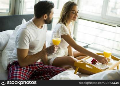 Couple having breakfast in their bed at home