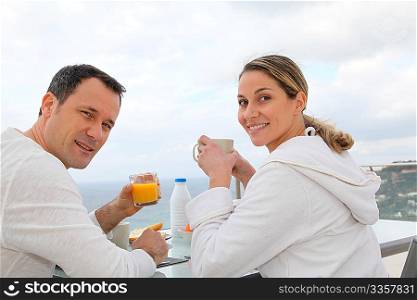 Couple having breakfast in their home terrace