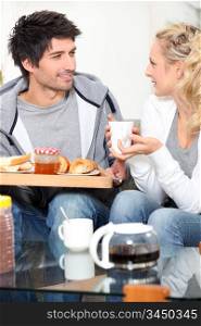 Couple having breakfast together on sofa