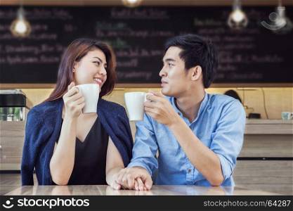 couple having coffee and hold hand in love together in cafe