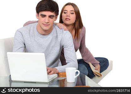 Couple having coffee and looking at laptop screen