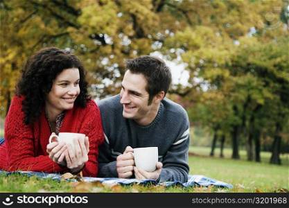 Couple having coffee in a park