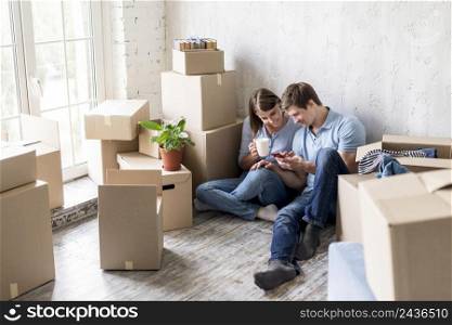 couple having coffee while packing move out house