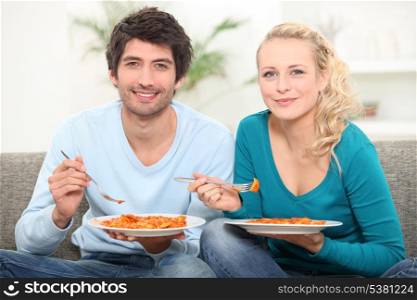 couple having dinner on the couch