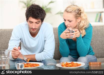 Couple having dinner on the sofa