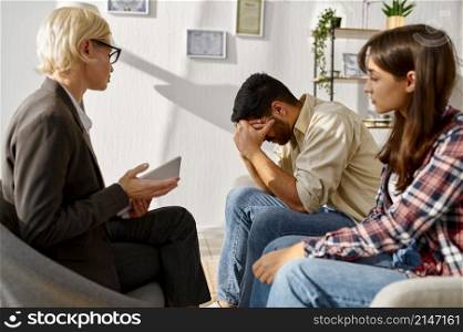 Couple having emotional speech explaining something to each other. Therapy session. Couple having emotional speech during therapy session