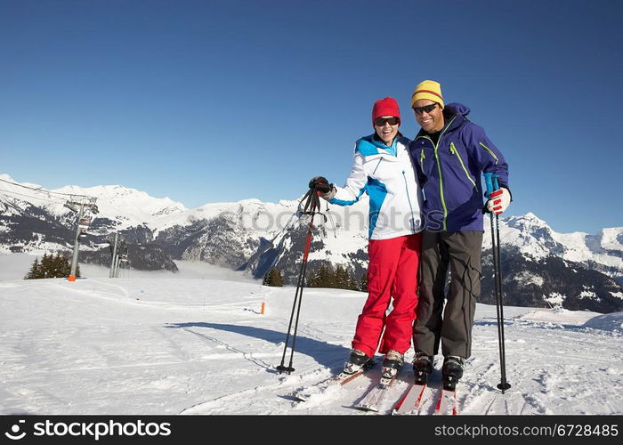 Couple Having Fun On Ski Holiday In Mountains