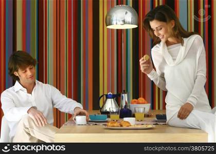 Couple having healty breakfast at home, eating cereals, fruits and drinking orange juice
