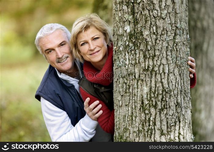 Couple hiding behind tree